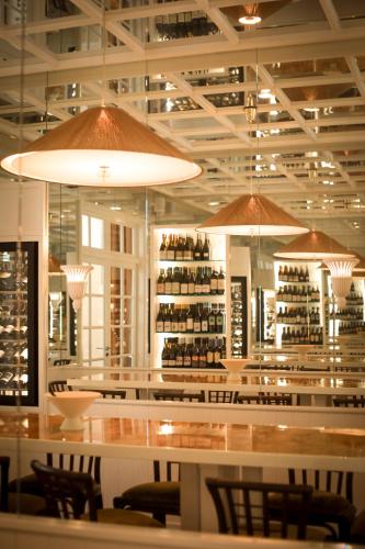 a restaurant with a bar with bottles of wine at LILOU in Hyères