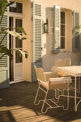 a patio with a table and chairs and a door at LILOU in Hyères