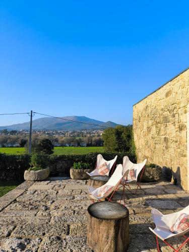 a group of chairs sitting next to a tree stump at Hotel Paço de Vitorino in Ponte de Lima