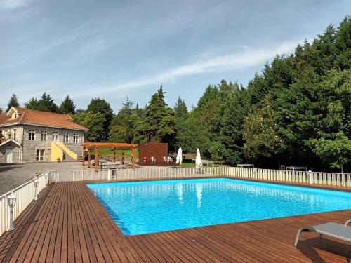 a swimming pool on a wooden deck with a playground at Casas do Souto in Lousada