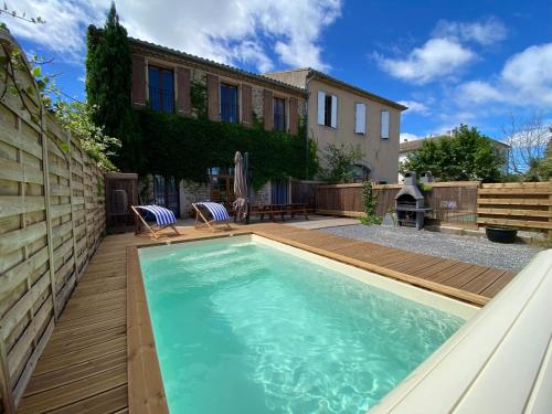 une piscine avec une terrasse en bois et une maison dans l'établissement Maison indépendante, canal du Midi, Piscine, à Homps