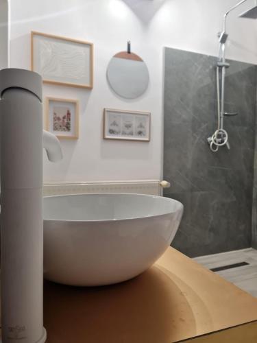 a white bath tub sitting on a counter in a bathroom at Vila cu Ciubar & Jacuzzi - Sunset Hill House in Cuvin