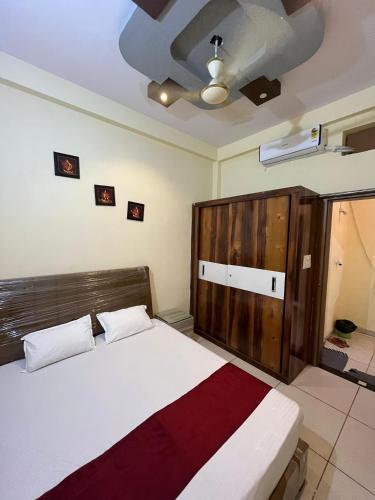 a bedroom with a bed and a wooden headboard at Dream Ashoka Homestay in Ujjain