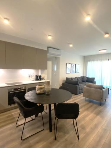 a kitchen and a living room with a table and chairs at Sunset Gardens - Holiday Apartments - by TLV Living in Limassol