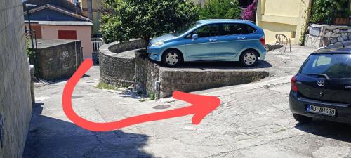 a blue car is parked next to another car at Serenita Stone House in Becici