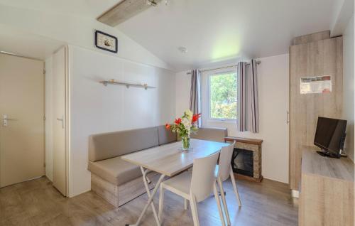 un salon avec une table, des chaises et une télévision dans l'établissement Pet Friendly StaCaravan, à Saint-Georges-de-Didonne