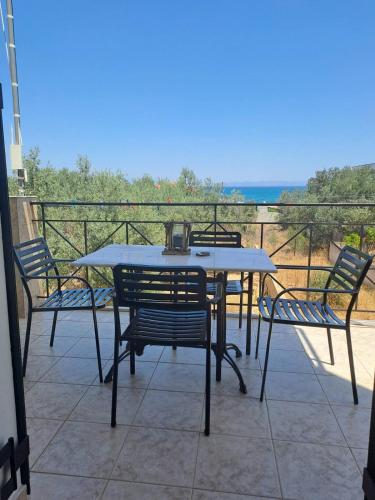 a table and chairs on a balcony with a view at Flisvos Apartments in Megalochori