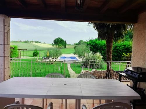 une table sur une terrasse avec vue sur un terrain de golf dans l'établissement Location Bernadas sur paradise-location-maison, à Montaigu-de-Quercy