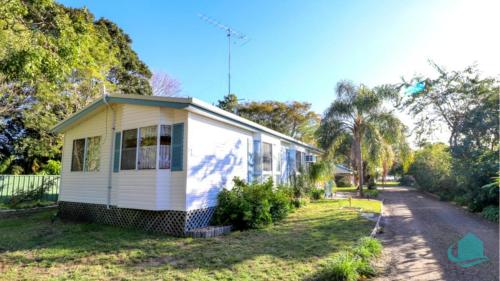 ein kleines weißes Haus am Straßenrand in der Unterkunft Bromyard Cottage in Swansea