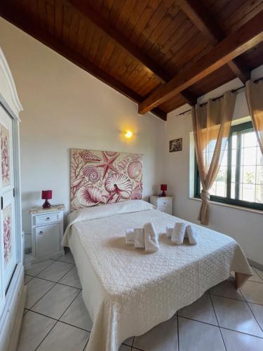 a bedroom with a bed with two towels on it at Villa Salentina in Sant'Isidoro