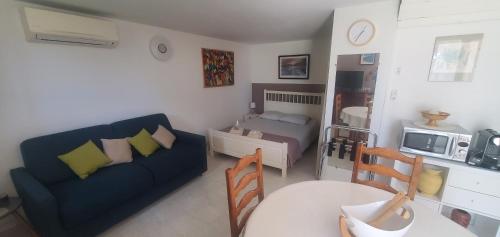 un salon avec un canapé et un lit dans l'établissement Jolie Studio en rez de jardin a L'Estaque Mourepiane, à Marseille