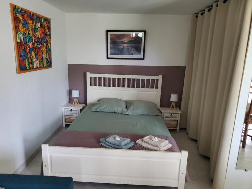 une chambre avec un lit avec deux serviettes dessus dans l'établissement Jolie Studio en rez de jardin a L'Estaque Mourepiane, à Marseille