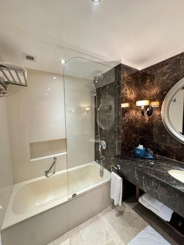a bathroom with a shower and a tub and a sink at Four Points by Sheraton Lahore in Lahore