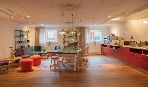 a kitchen with red cabinets and a table and chairs at Quality Hotel The Mill in Malm&ouml;
