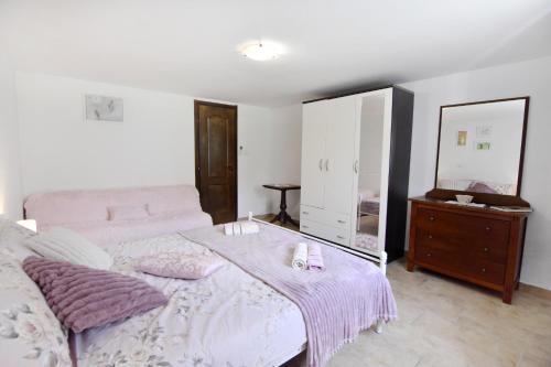 a bedroom with a bed and a dresser and a mirror at Vila Vesna in Grožnjan