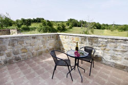 a table and chairs on a patio with a bottle of wine at Vila Vesna in Grožnjan