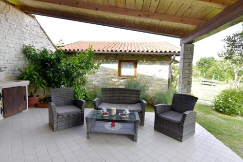 a patio with wicker chairs and a table on a patio at Vila Vesna in Grožnjan