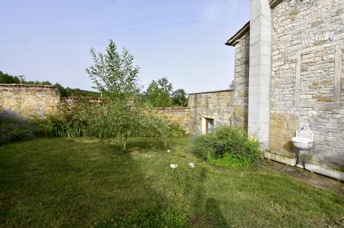 an old stone building with a yard with flowers at Vila Vesna in Grožnjan
