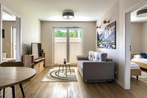 a living room with a couch and a table at RentPlanet - Apartamenty Zakopiańskie in Zakopane