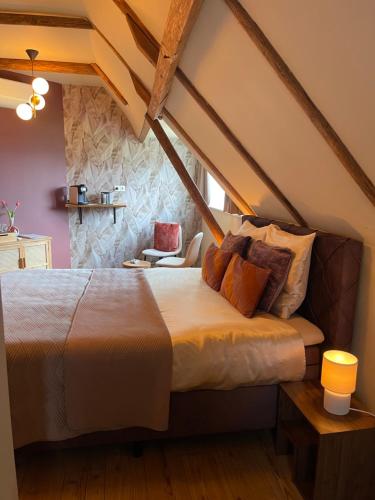 a bedroom with a large bed in a attic at B&B Het Molenhuisje Winschoten - met woonkamer & keuken in Winschoten