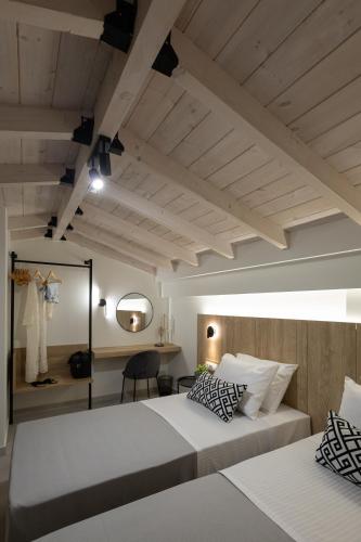 a bedroom with two beds and a desk at Olympus Mare Village Seaside Pool Villas in Katerini