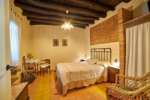 a bedroom with a bed and a table and chairs at El Zarzo in Fuenteheridos
