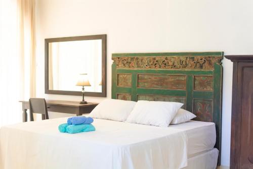 a bedroom with a white bed with a green headboard at Villa Moya Borobudur in Mendut