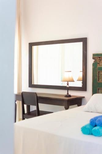 a bedroom with a bed and a desk with a mirror at Villa Moya Borobudur in Mendut