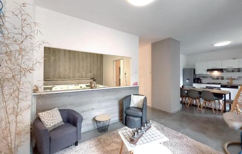 a living room with two chairs and a kitchen at Gorgeous Apartment In Le Thillot in Le Thillot
