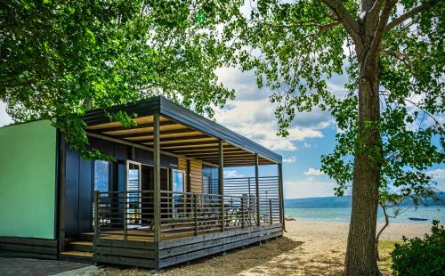 a small house on the beach with a tree at Camping Almissa in Omiš