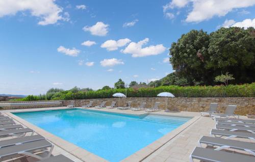 a swimming pool with lounge chairs next to a stone wall at Lovely Home In Bessas in Bessas
