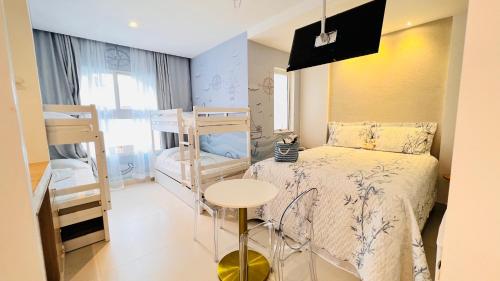 a bedroom with two bunk beds and a table at D'Blue Búzios Hotel Boutique in Búzios