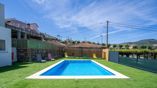 a swimming pool in the yard of a house at Alojamento Armando Monteiro in Folgosa