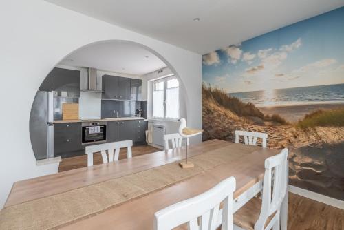une cuisine et une salle à manger avec un tableau de la plage dans l'établissement Parenthèse marine - Le Portel, à Le Portel