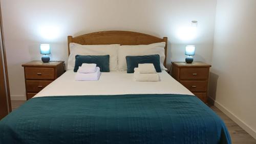 a bedroom with a large bed with two night stands at Casa do Forno d'Aldeia in Mouços