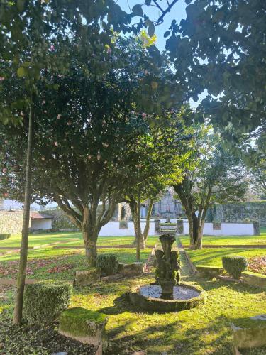 a fountain in the middle of a park with trees at Hotel Paço de Vitorino in Ponte de Lima