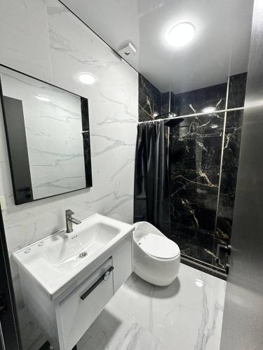 a white bathroom with a sink and a toilet at Hotel black sea in K'obulet'i