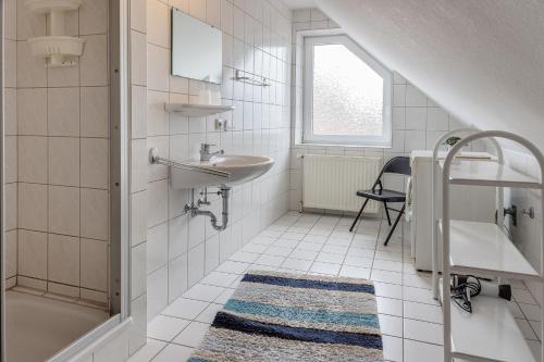 a white bathroom with a sink and a shower at 50188Ferienwohnung Windspiel in Harlesiel