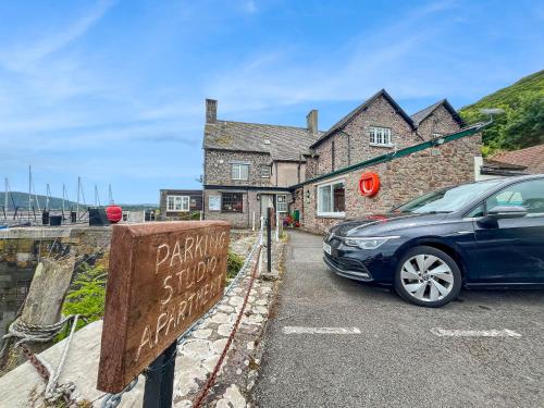 a car parked in a parking lot in front of a building at Harbour House Studio, Porlock Weir in Culbone