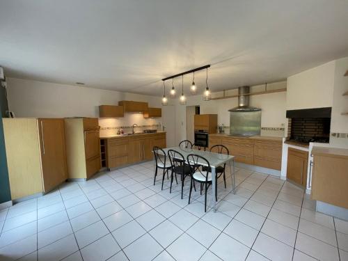 a large kitchen with a table and chairs in it at Maison familiale domaine val Léose in Grand-Fougeray
