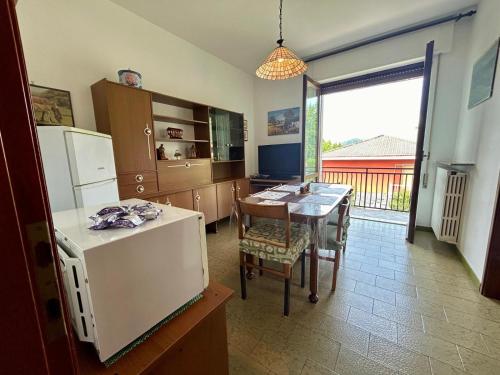 a kitchen with a table and a refrigerator at Kibilu - Cittiglio vicinanze Ospedale, Lago Maggiore in Cittiglio