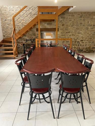 a large wooden table and chairs in a room at Maison familiale domaine val Léose in Grand-Fougeray