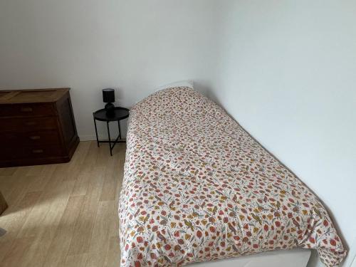 a bed with a comforter on it in a bedroom at Maison familiale domaine val Léose in Grand-Fougeray