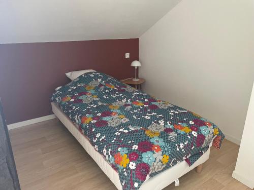 a bedroom with a bed with a quilt on it at Maison familiale domaine val Léose in Grand-Fougeray
