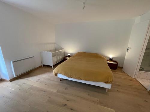 a bedroom with a bed and a wooden floor at Maison familiale domaine val Léose in Grand-Fougeray
