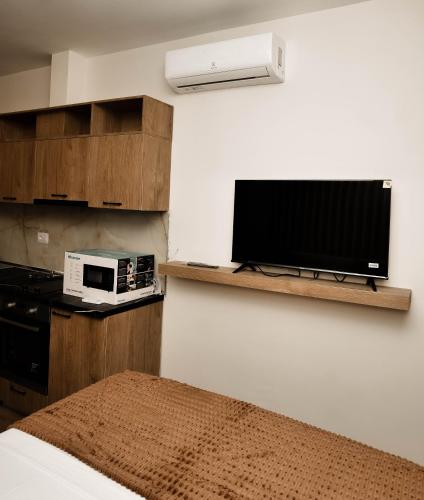 a bedroom with a tv and a microwave on a shelf at Bulevardi blu Kamez 3 in Kamëz