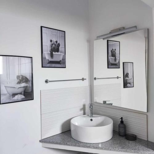 a white bathroom with a sink and a mirror at Giannis house in Makri