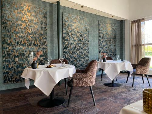a dining room with two tables and a wall mural at Thermen Bad Nieuweschans in Bad-Nieuweschans