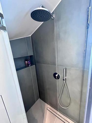 a shower with a glass door and a shower head at Aetheria Apartment with Private Pool in Kampos Paros