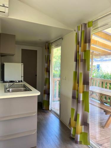 une cuisine avec un évier et une fenêtre dans l'établissement Camping la Faloise - Mobil-home 2 chambres, à Angicourt